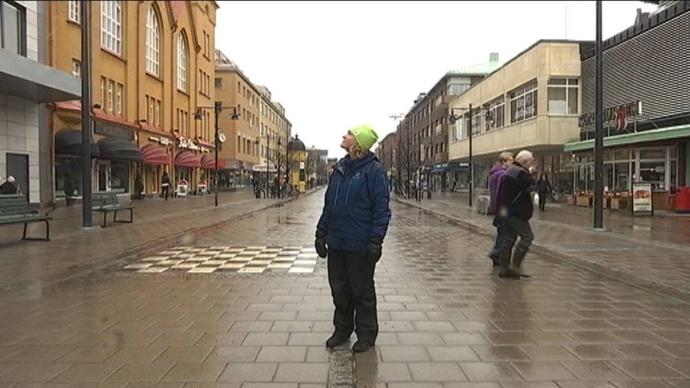 En kvinna står mitt i en central gata i Luleå.
