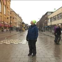 En kvinna står mitt i en central gata i Luleå.