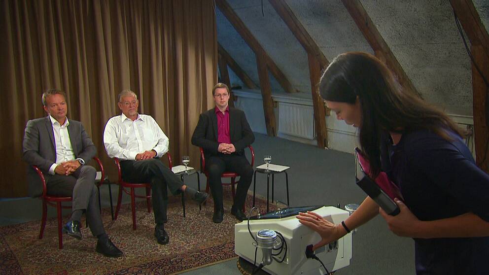 Foto: SVT Åsa Avdic visar Slim fit prop-maskinen för Per-Anders Sunesson från Socialstyrelsen, professor och överläkare Stephan Rössner och Martin Gustafsson från på Elsäkerhetsverket.