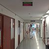 En korridor på sjukhuset där en läkare går, en kvinna med grön tröja