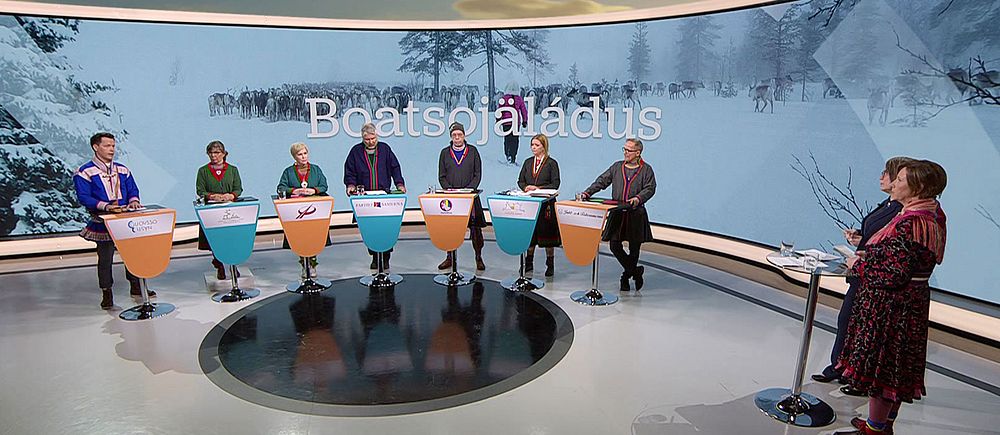 Åtta deltagare i samiska kläder i en tv-studio med vinterlandskap i bakgrunden. Bild från SVT:s partiledardebatt inför val till Sametinget 18 maj.