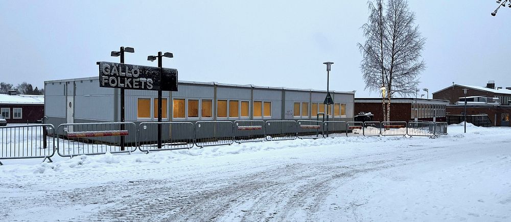 En barackbyggnad omgiven av snö och vinterlandskap.