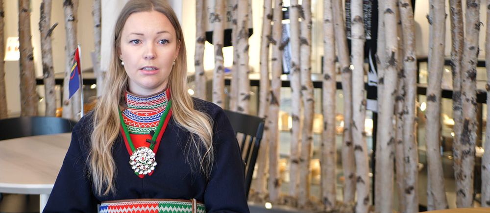Naadja Edlund Östergren framför en spaljé av björkar