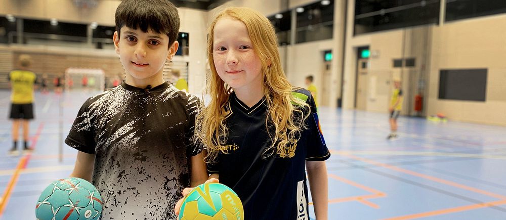 två unga pojkar i inomhushall med handbollar i händerna, tränar gratis med HP Warta i Biskopsgården i Göteborg
