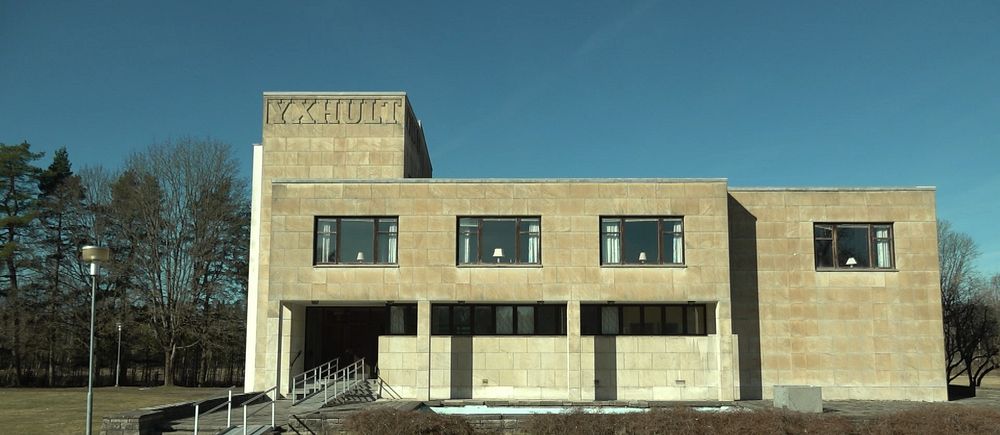 Modern byggnad med rak arkitektur under klar himmel. Yxhultkoncernens före detta huvudkontor i Hällabrottet.