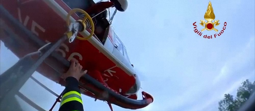 Brandman håller i en räddningshelikopter under en räddningsoperation i luften.