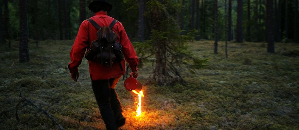 Man tänder eld på ris i skogen.