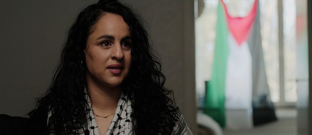 Sabrin El Hassi intervjuas, Palestinaflagga syns i bakgrunden.