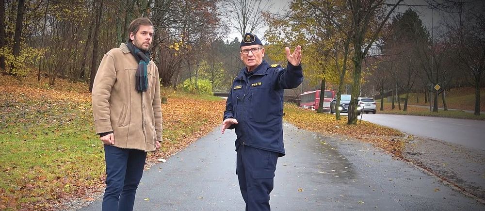 Reporter David Nilsson Hamne och polis står vid väg och polisen pekar mot kameran