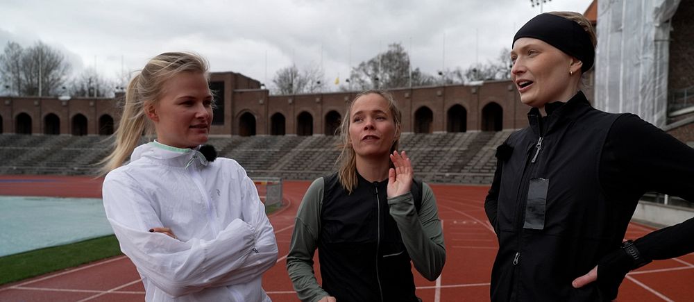 Tre tjejer i löparoutvits på löparbanan på Stockholms Stadion.