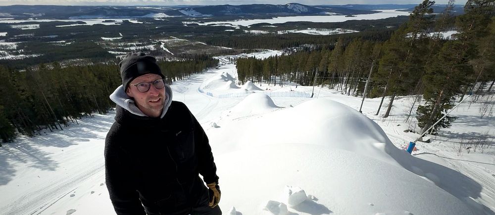 Daniel Abrahamsson, utvecklingsansvarig, står på en stor snöhög i en av Nalovardos skidbackar.