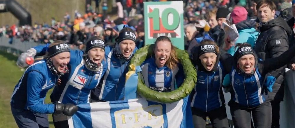 Sex glada löpare jublar med IFK Göteborgs fana och segerkrans efter målgång.