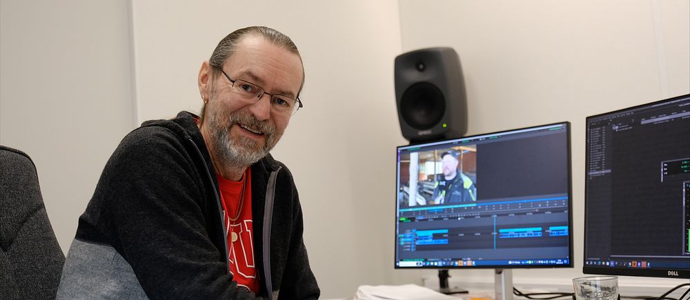 Reporter Rino Rotevatn vid skrivbord med två bildredigeringsskärmar och högtalare.