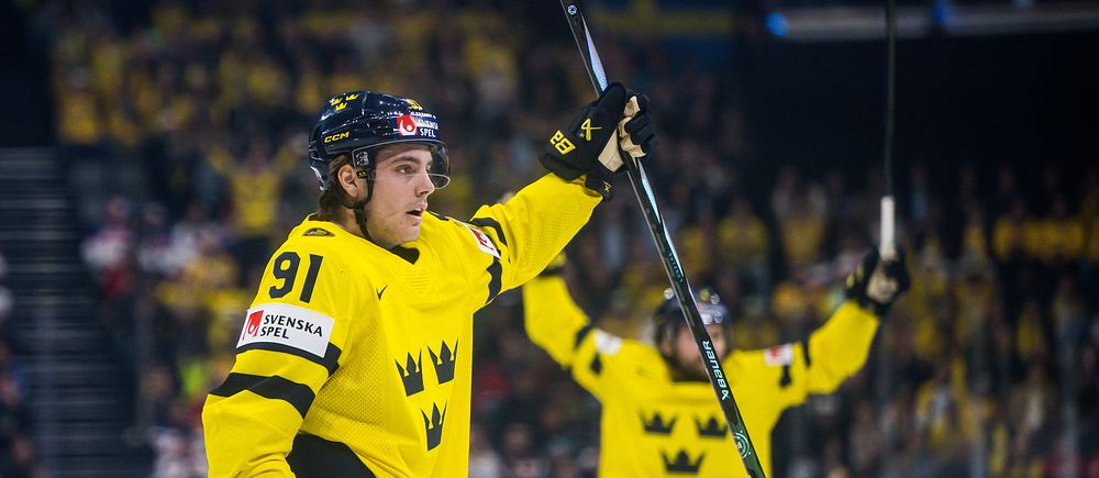 Ishockeyspelare i Tre Kronor jublar efter mål under match inför publik.