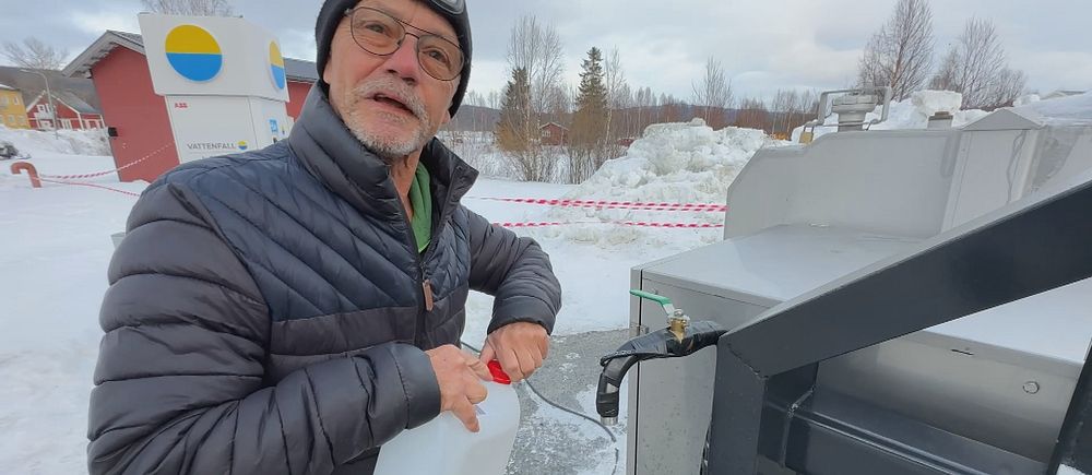 Runar Brännlund i Ammarnäs fyller en vit behållare med vatten från en utomhuskran i kallt väder.