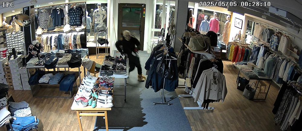 Bild från övervakningskamera som visar tjuv med dödskallemask inne i en butik.