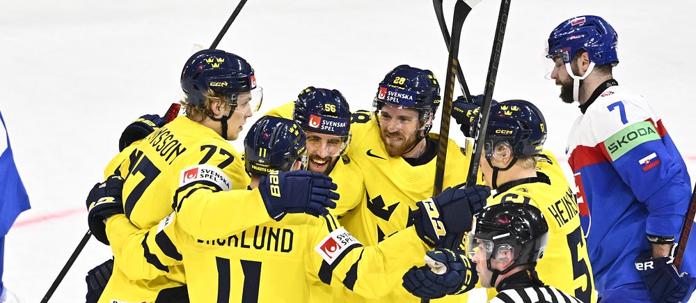 Svenska ishockeyspelare firar mål mot motståndarlag, domare i förgrunden.