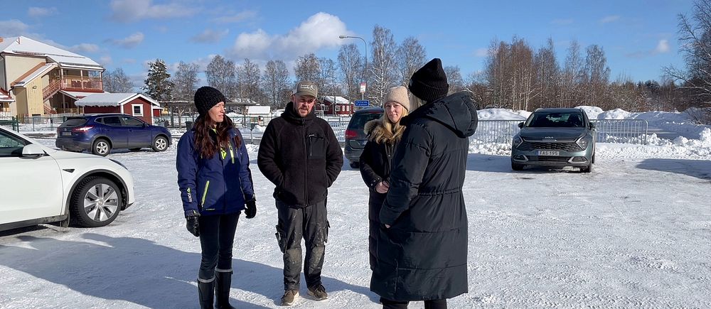 Tre personer står iklädda täckjackor framför skolan i Särna