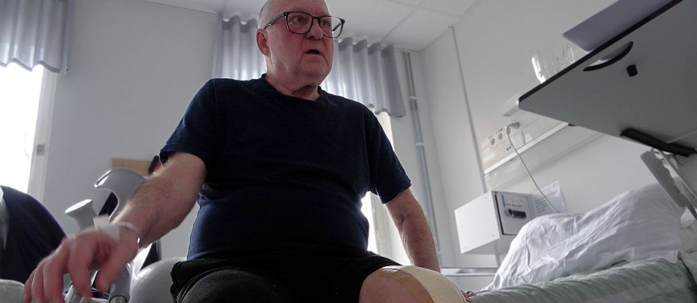 Jan Berman sitter med nyopererat knä på en sjukhussäng.