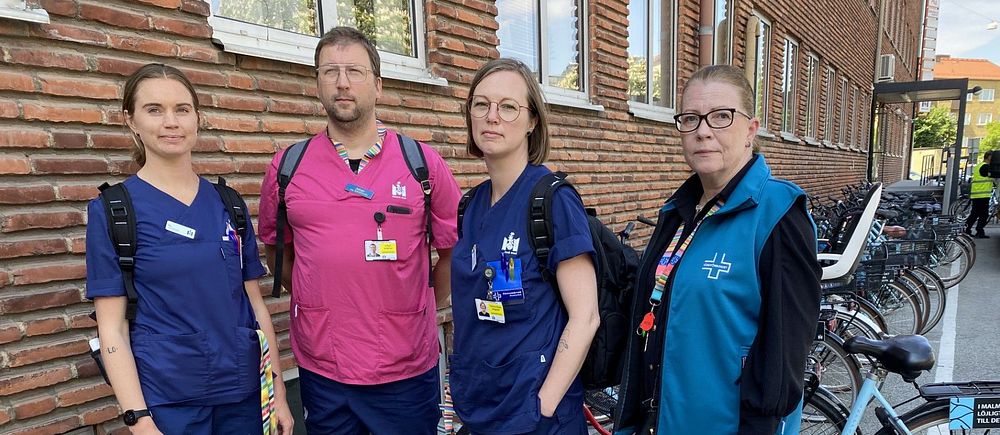 fyra personer som jobbar inom vården står framför ett cykelställ