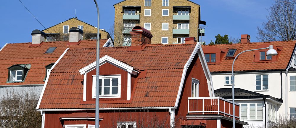 bostadspriserna forsatte att öka i maj. bild på en röd villa och ett lägenhetshus i tegel i bakgrunden.
