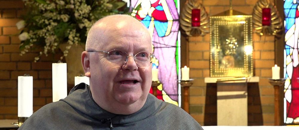 Pater Joseph Maria Nilsson står framför ett altare
