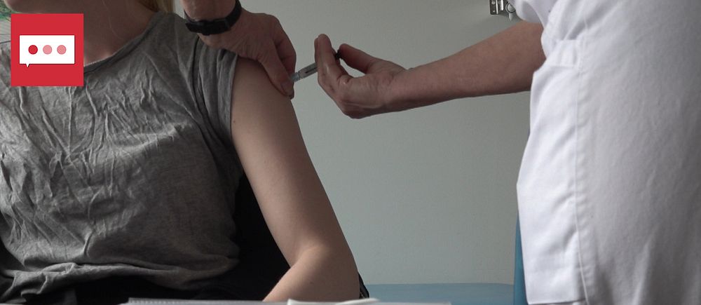 En kvinna blir vaccinerad, ett stick i armen
