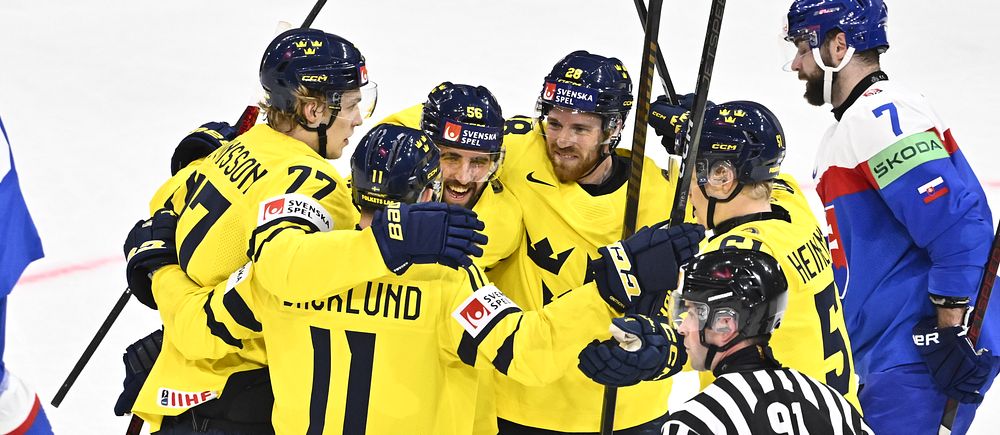 Svenska ishockeyspelare i gula tröjor firar mål mot ett lag i blå och röd utrustning.