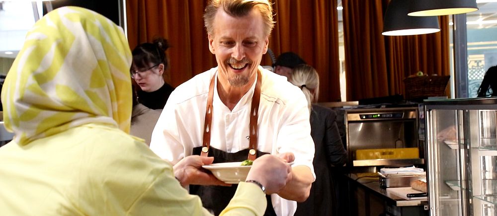 Kocken Paul Svensson serverar en kvinna soppa.