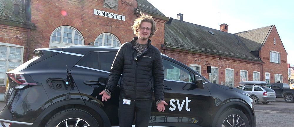 Reporter framför SVT-bil vid Gnesta tågstation.