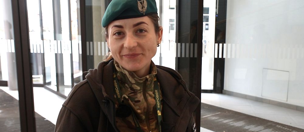 Kvinna  i militärkläder som ler