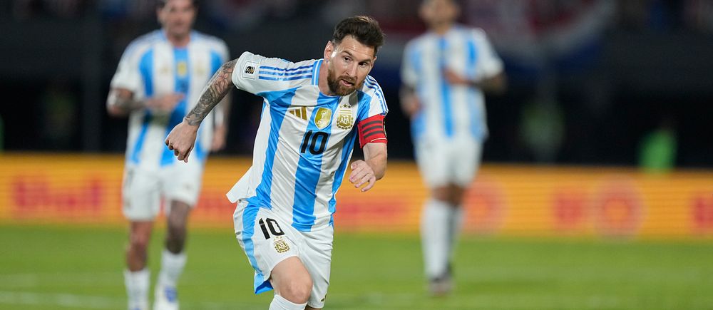 Lionel Messi driver bollen i argentinsk landslagströja under fotbollsmatch.