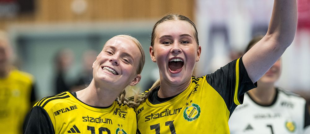 Två handbollsspelare i gula matchtröjor firar på planen, målvakt syns i bakgrunden.