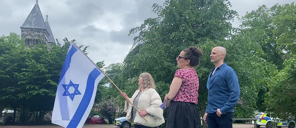 Tre personer som vajar en Israelflagga i Lundagård.