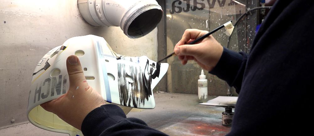 David Gunnarsson målar en målvaktsmask.