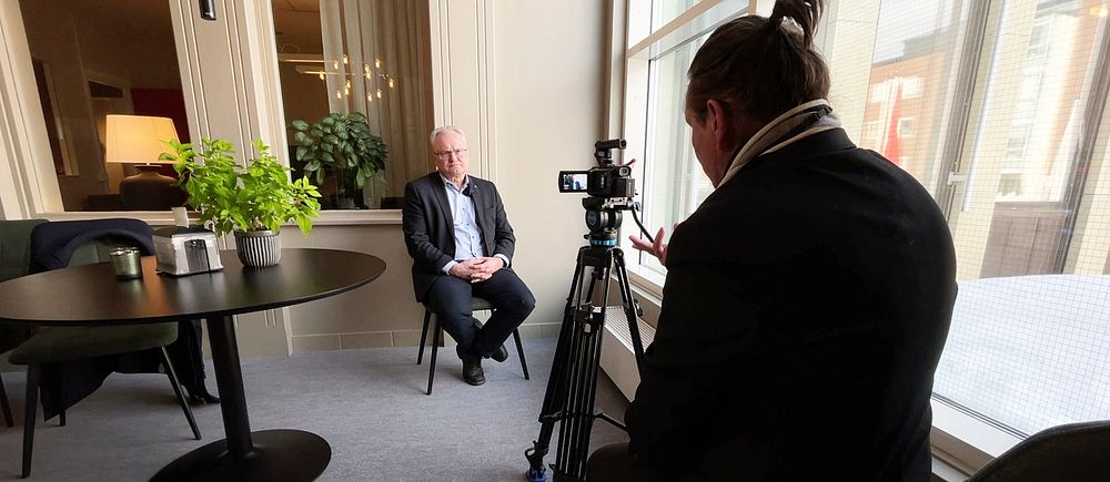 Glenn Nordlund sitter på en stol framför en kamera vid en intervju.