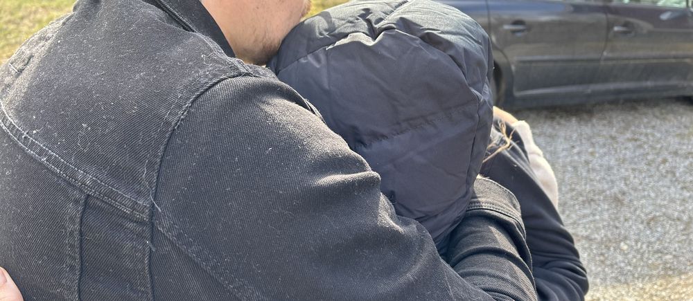 ett anonymt par står och håller om varandra på mordplatsen i Kramfors
