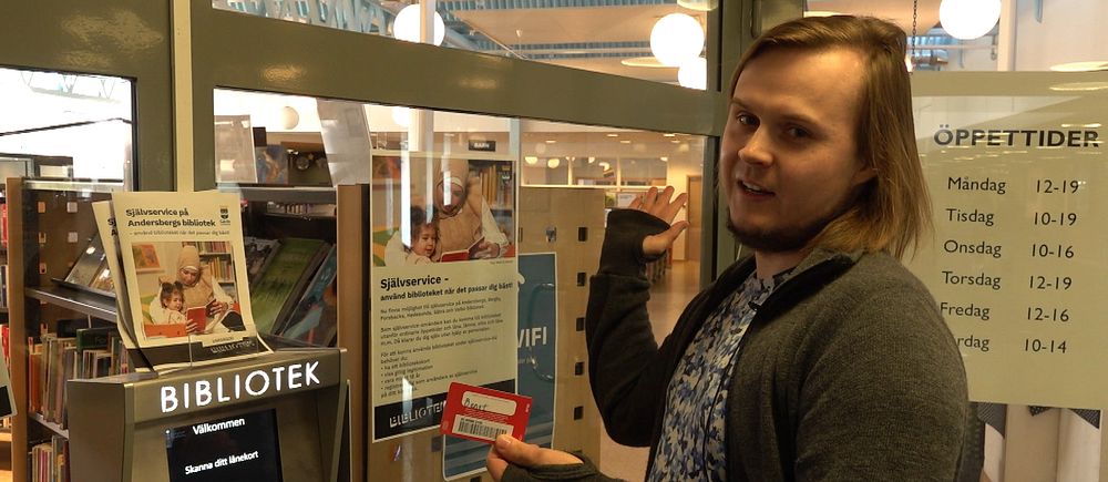 En bibliotekarie visar upp hur man kan komma in i ett bibliotek på Andersberg, Gävle med hjälp av självservice.