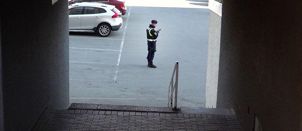 Vaktmästare i uniform står på en parkeringsplats i Biskopsgården efter att ett dubbelmord inträffat i stadsdelen på Hisingen i Göteborg