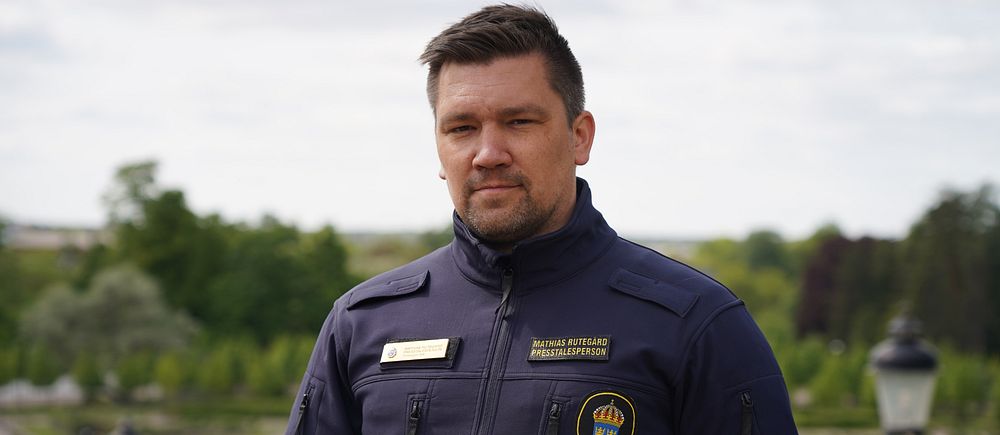 Man med polisens logotyp på bröstet.