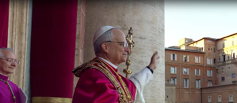 Påve i traditionella kläder håller handen mot en pelare vid Peterskyrkan i Vatikanen.