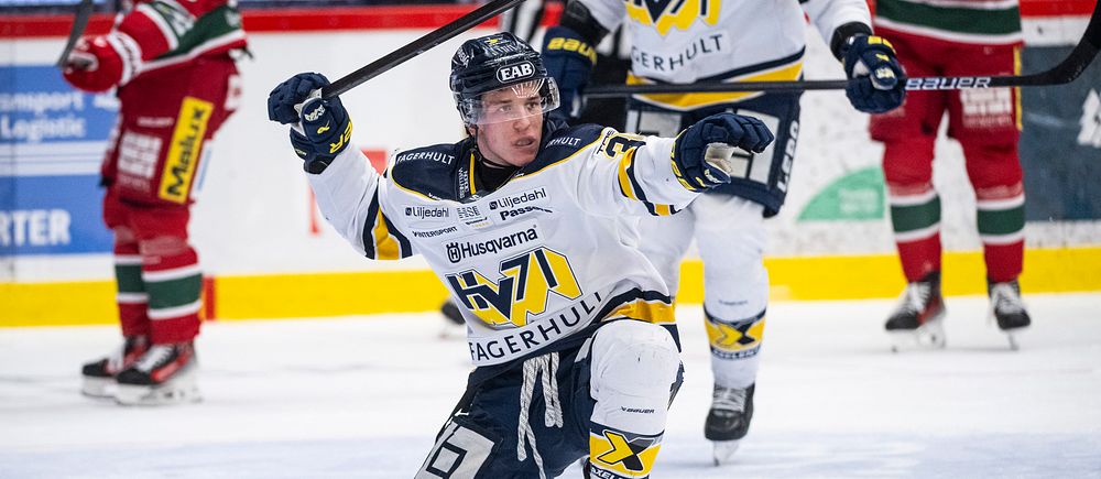 Hockeyspelare firar mål på isen, knästående med uppsträckt arm. Motståndare i bakgrunden.