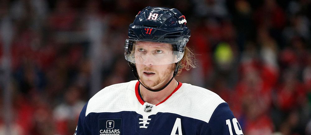 Washington Capitals-spelare i mörkblå hockeytröja med nummer 19 på isen.