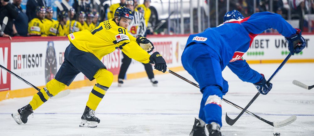 Ishockeyspelare från Sverige och Slovakien kämpar om pucken under en match.
