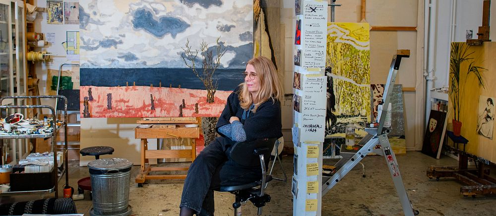 Karin Mamma Andersson sitter på en stol i sin ateljé.