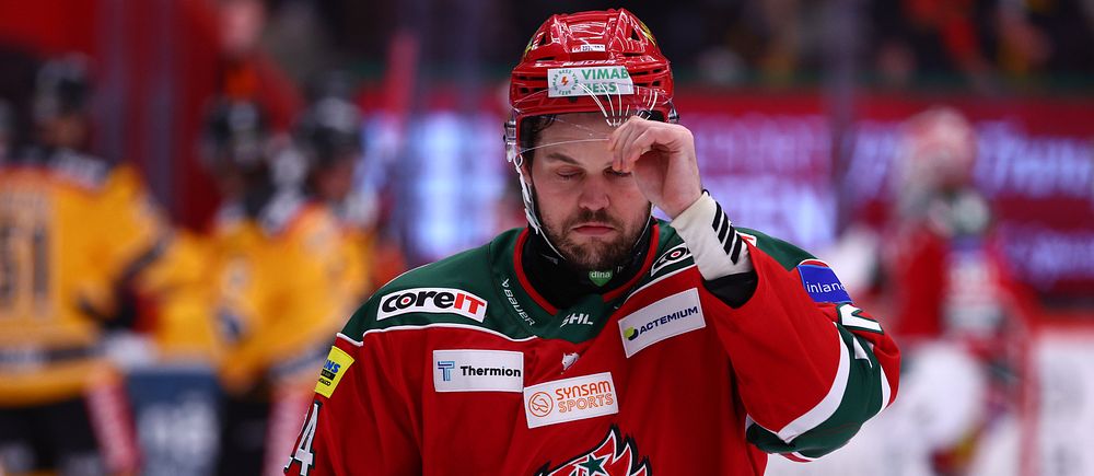 Ishockeyspelare i Modos röda dräkt på isen under match.