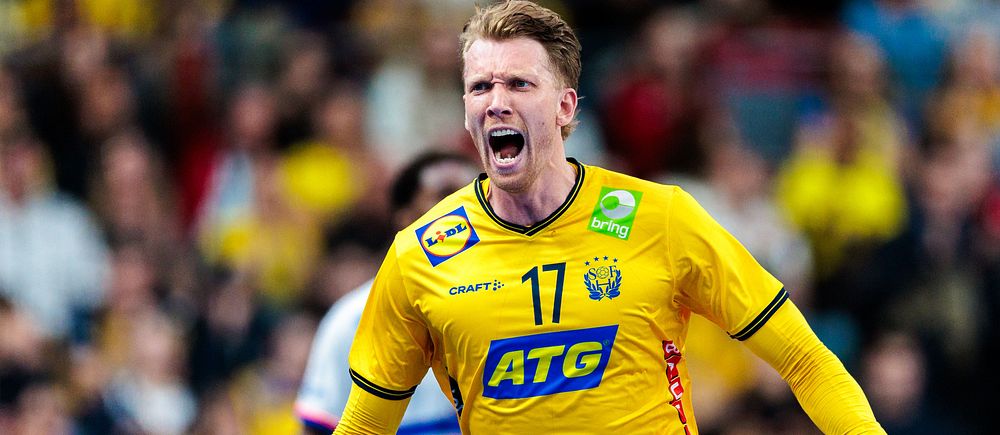 Handbollsspelare i Sveriges gula landslagströja under match med publik i bakgrunden.