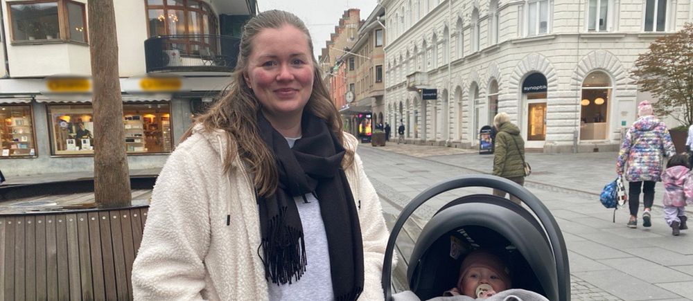 Sandra Bälgwik står i centrala Eskilstuna intill sin dotter i en barnvagn.