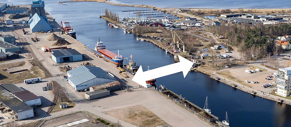 Flygbild över en hamnen och Nissans utlopp i Halmstad med en vit pil som visar vara den nya Söderbron ska byggas.