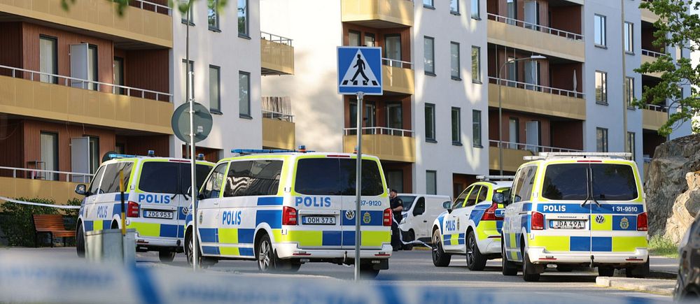 Flera polisbilar framför bostadshus i Bredäng